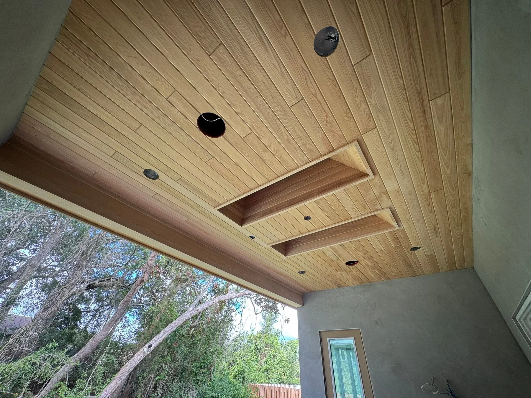 Natural-wood porch ceiling with recessed openings and contrasting trim