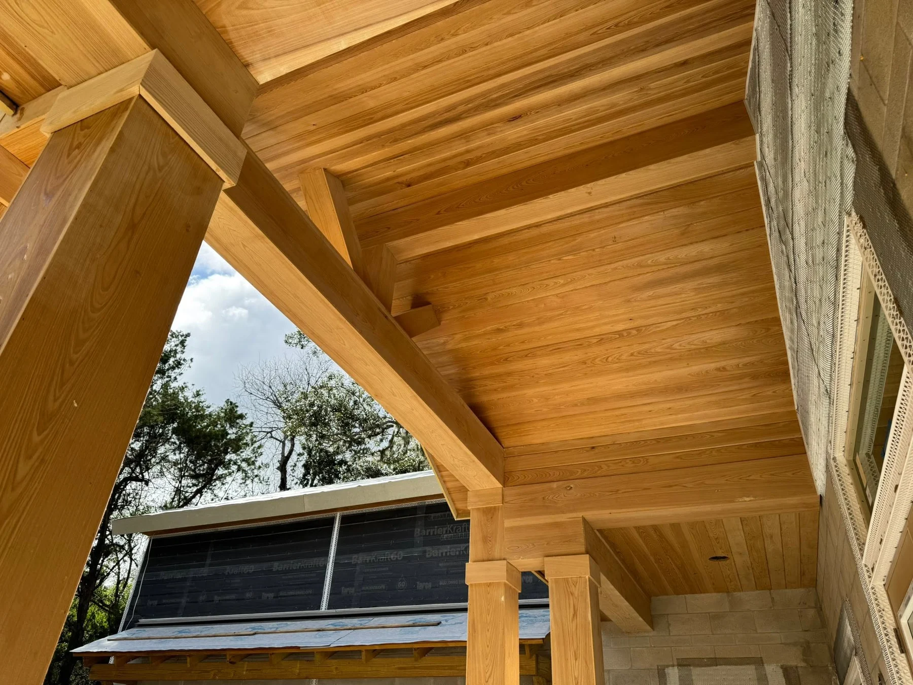 Close view of cedar porch ceiling, beams and detailed post wraps