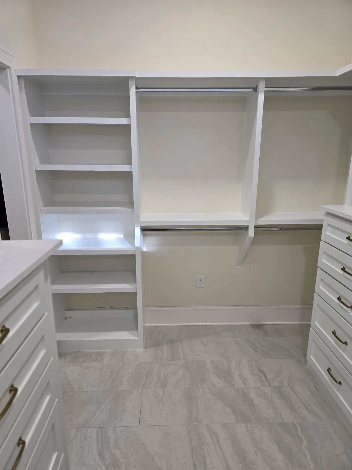 Custom white closet wall with hanging rails, shoe shelves and drawer towers