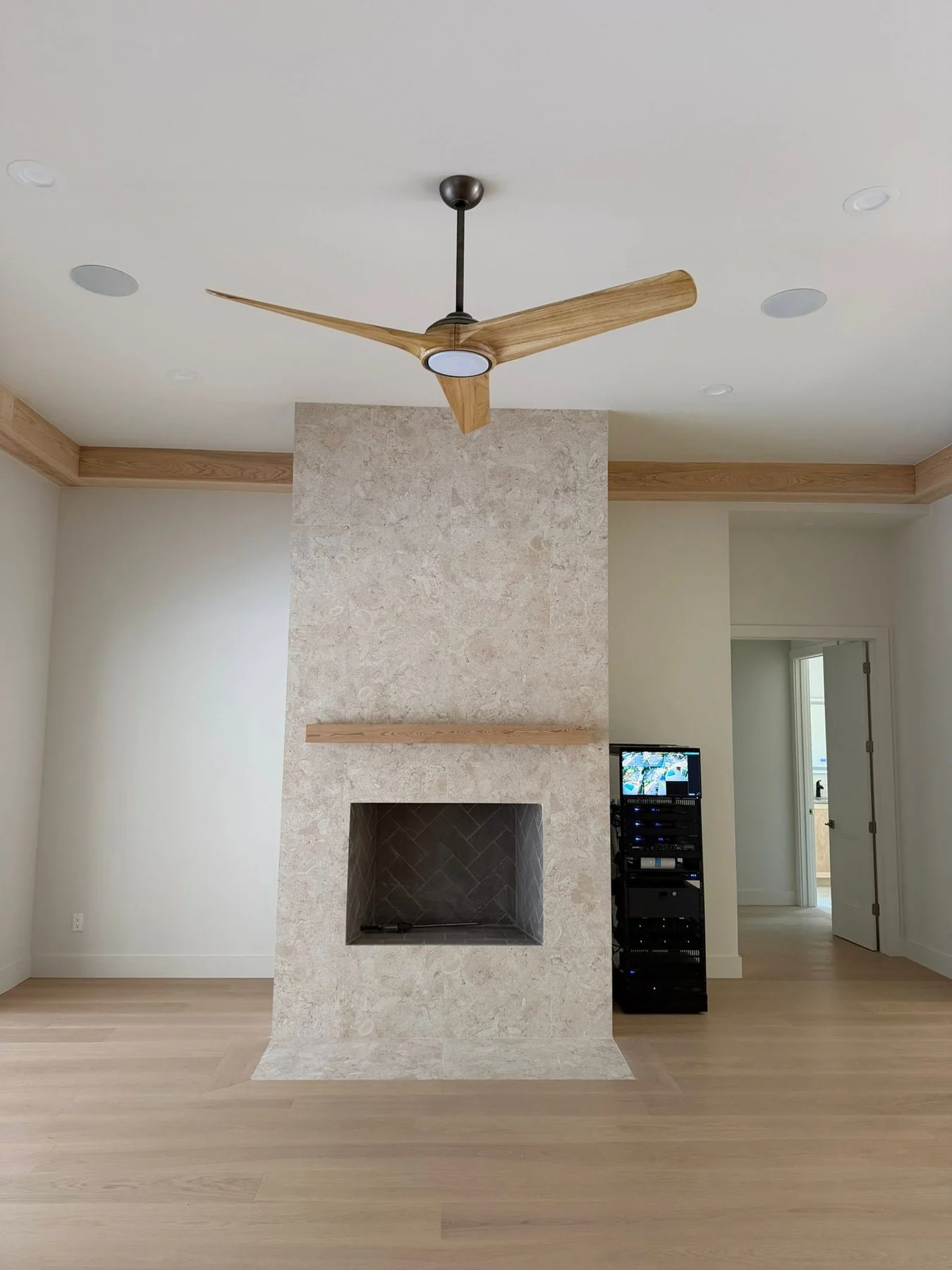 Stone fireplace with a slim wood mantel and matching perimeter ceiling trim