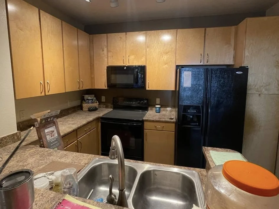 The same kitchen before cabinet refinishing, with natural tan cabinet fronts