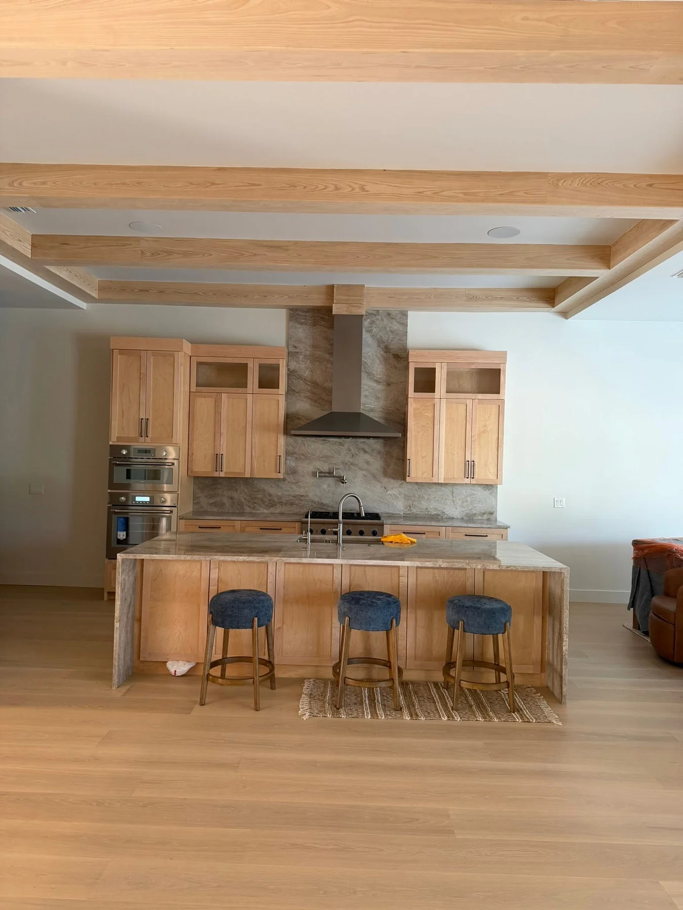 Natural-oak kitchen with custom island, cabinets and wood ceiling beams