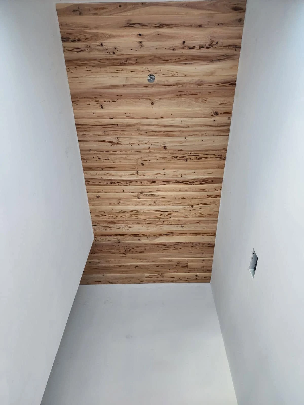 Narrow inset ceiling finished with character-rich wood planks